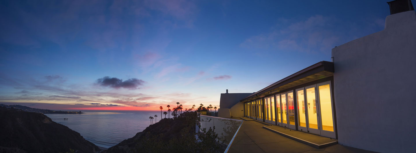 A building on UC San Diego's campus overlooking the ocean at sunset.